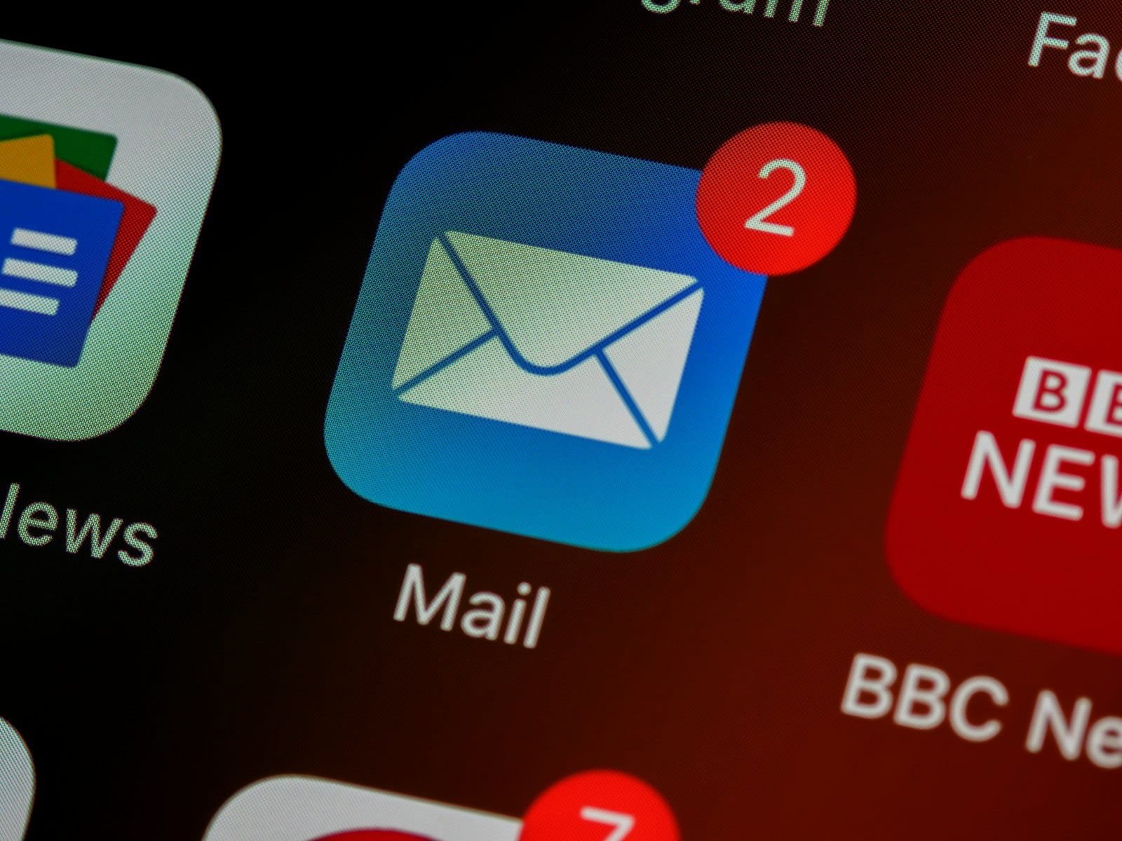 Smartphone home screen showing an email app with unread notification badges, representing email security and phishing protection for businesses.