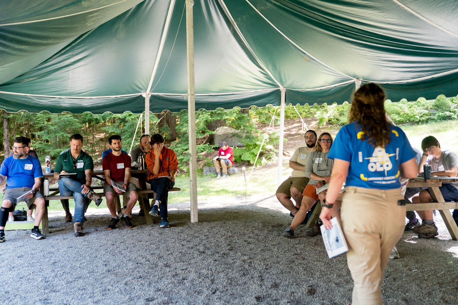 Nonprofit volunteers and staff gathered for a community outreach meeting, listening to a presenter discuss programs.
